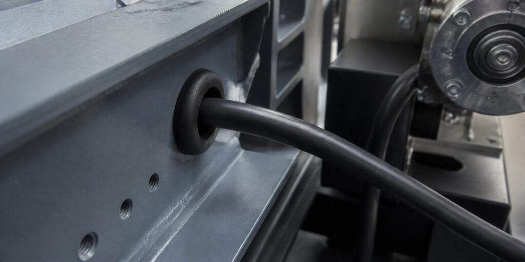 Industrial rubber grommet protecting a cable in machinery